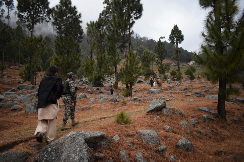 Pakistani reporters and troops visit the site of an Indian airstrike in Jaba, near Balakot, Pakistan, Tuesday, Feb. 26, 2019. Pakistan said India launched an airstrike on its territory early Tuesday that caused no casualties, while India said it targeted a terrorist training camp in a pre-emptive strike that killed a "very large number" of militants. (AP Photo/Aqeel Ahmed)