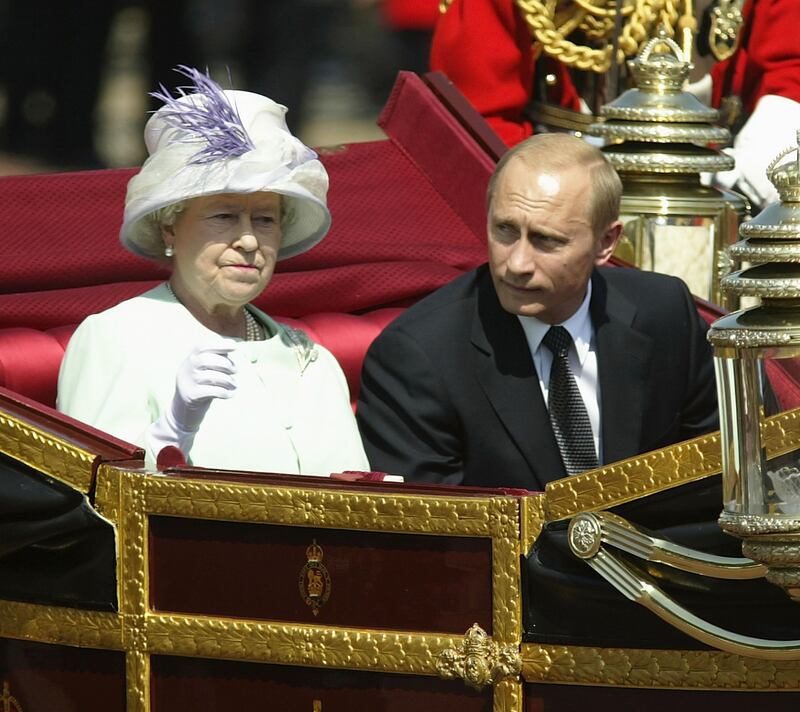 Russian President Vladimir Putin is accompanied by Queen Elizabeth during a procession on The Mall, London, in June 2003. Getty Images