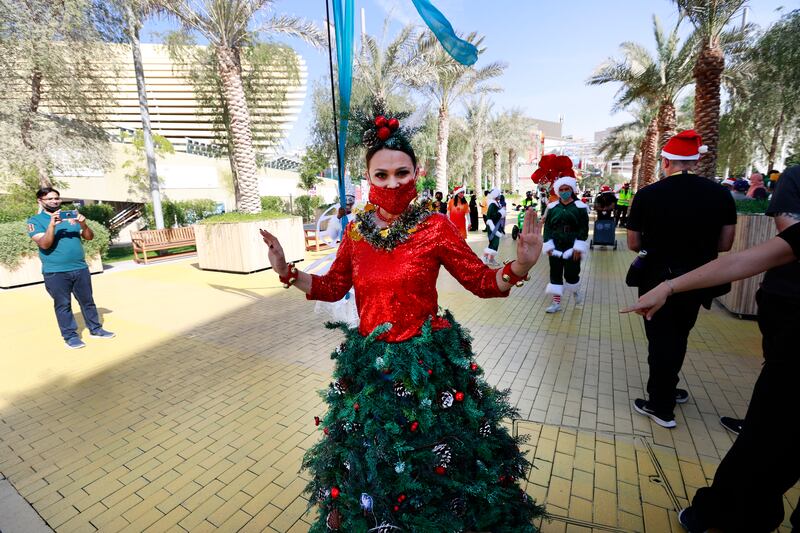 A spruce-looking performer in a Christmas tree outfit entertains Expo visitors.