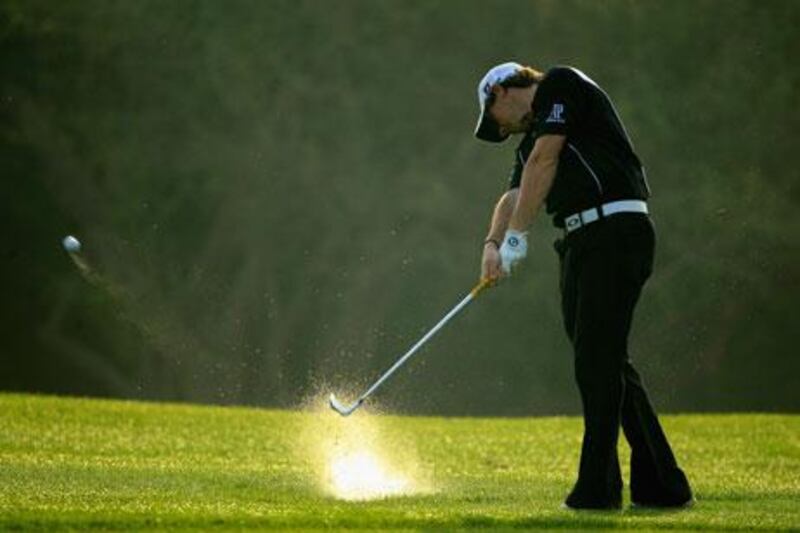 Rory McIlroy of Northern Ireland hits from the rough during the first round on the Majilis Course.