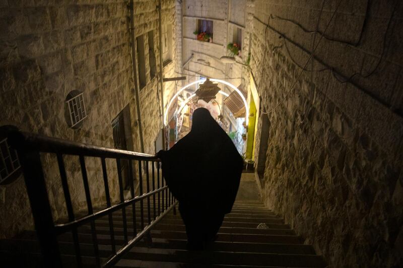 A women walks down a flight of stairs to a bustling central Amman on the eve of Ramadan.  EPA