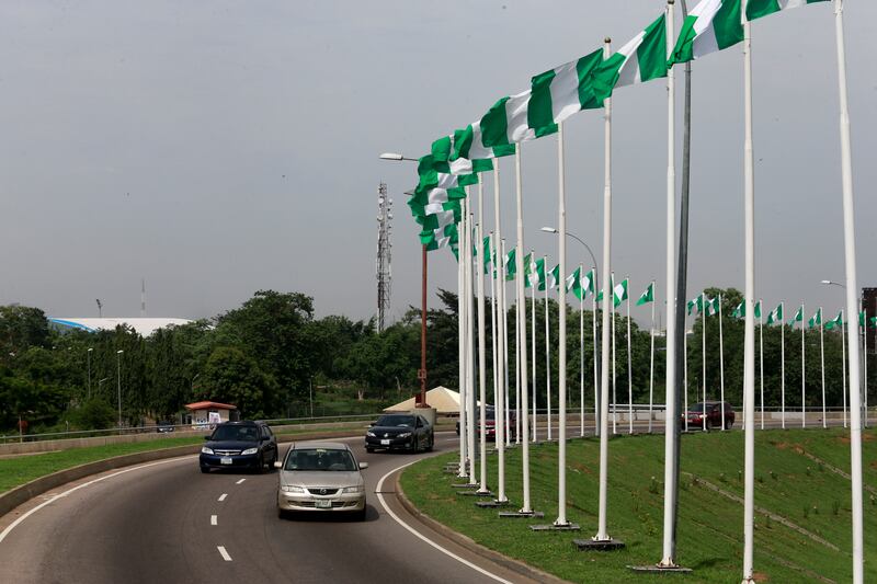 Cars drive past Nigerian national flags in Abuja, Nigeria. The country's state oil company NNPC is considering an initial share sale after posting the first profit in its 44-year existence. Reuters / Afolabi Sotunde