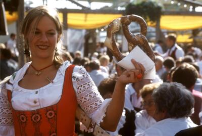 Young woman with giant pretzel in her hand at Oktoberfest (1)