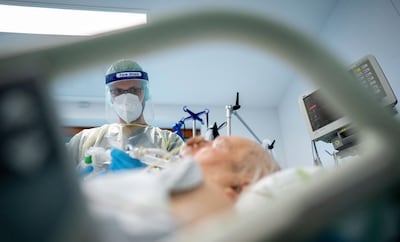 Intensive care nurse Sebastian treads on patient with COVID-19 in the intensive care unit of the Bethel Hospital in Berlin, Germany, Wednesday, Nov. 11, 2020 . This ward treats patients who have tested positiv on the coronavirus do not require ventilation. (Kay Nietfeld/dpa via AP)