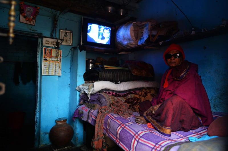 A cured patient of leprosy looks on as she watches television.
