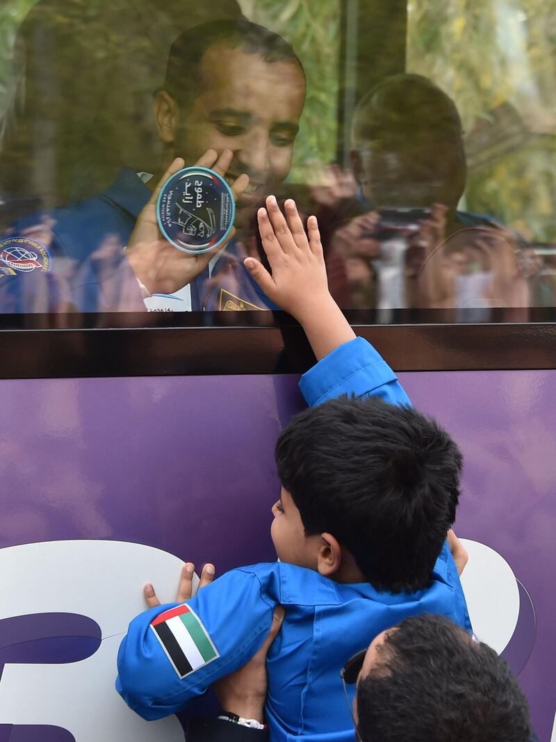 Crew member of the International Space Station (ISS) United Arab Emirates' astronaut Hazza Al Mansouri waves from inside a bus during a farewell ceremony outside the Cosmonauts' hotel on his way to the Russian-leased Baikonur cosmodrome in Kazakhstan on September 25, 2019. Al Mansouri will make history by becoming the first Arab on the International Space Station said he had received support from around the world before his "dream" mission. / AFP / Vyacheslav OSELEDKO

