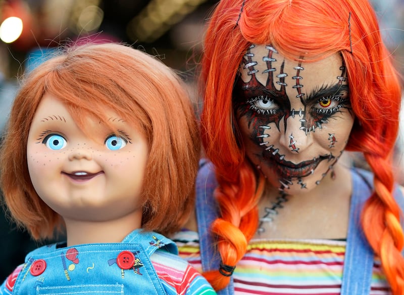 A cosplayer dressed as Chucky arrives with a Chucky doll for the final day of the New York Comic Con. AFP 