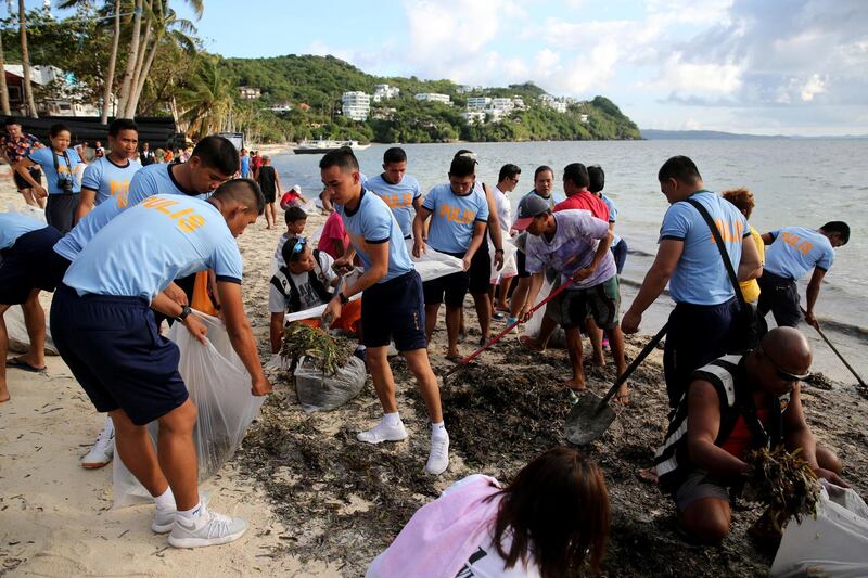 Policemen collect seaweeds during a clean up drive along the beachfront as the government implements the temporary closure of the country's most famous beach resort island of Boracay, in central Aklan province, Philippines, Thursday, April 26, 2018. Boracay, famed for its white-sand beaches, closes for up to six months to recover from overcrowding and development. Aaron Favila / AP Photo