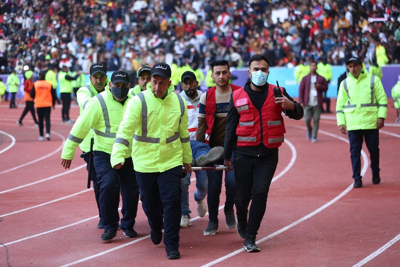 An injured football fan is carried into an emergency area at the stadium.  AFP