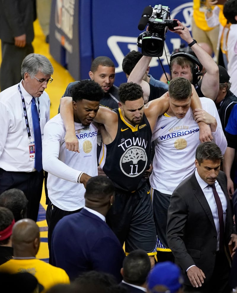 Golden State Warriors guard Klay Thompson is helped off the court after being fouled by Toronto Raptors guard Danny Green. EPA