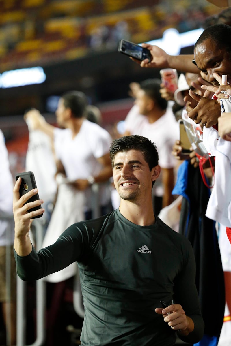 Real Madrid goalkeeper Thibaut Courtois takes a selfie with fans. Reuters