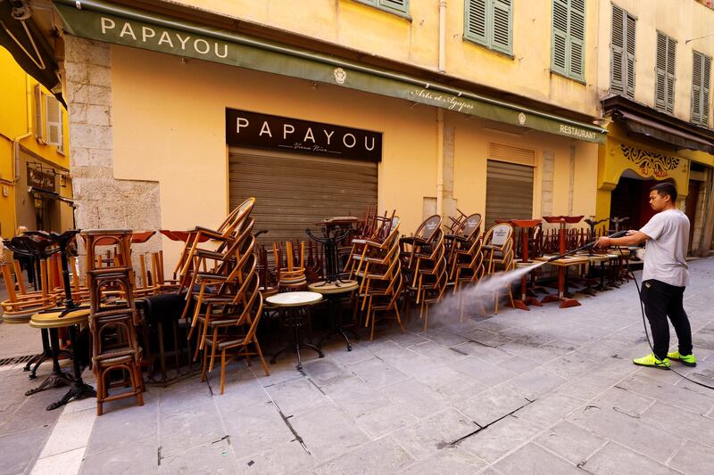 An employee cleans tables and chairs during preparations for the reopening of restaurants and bars in Nice, France. Reuters