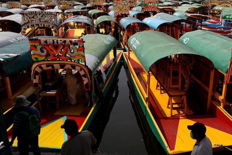 Men wait in a distanced line to get tested for Covid-19 aboard a trajinera, one of the colorful wooden boats popular with tourists and revelers, in the Xochimilco district of Mexico City. AP Photo