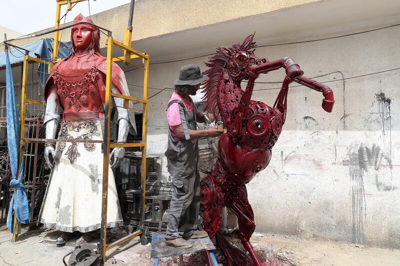 Tunisian artist Mohamed Al-Sharaiti, 53, manufactures human- and animal-shaped sculptures from spare parts of cars at his workshop in Nabeul, Tunisia, 17 September 2021.  Al-Sharaiti first cleans the scraps before assembling his creations.  Once put together, he burns the sculpture with fire to rid it of oils, impurities, and dirt, then proceeds with the painting process according to the customer's request.  Some customers want him to paint the models while others prefer them unpainted.   EPA / MOHAMED MESSARA