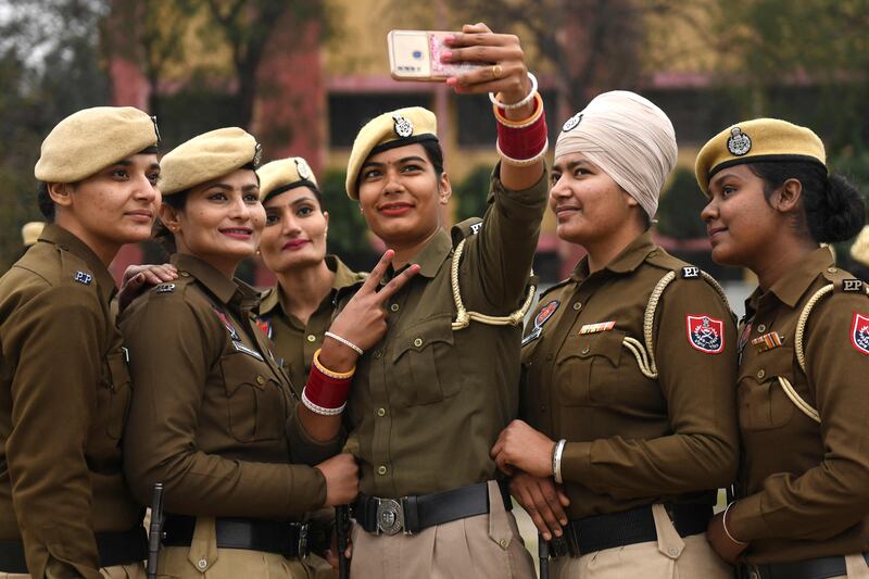 Women police officers take selfie pictures during a rehearsal for a Republic Day parade in Amritsar, India. AFP