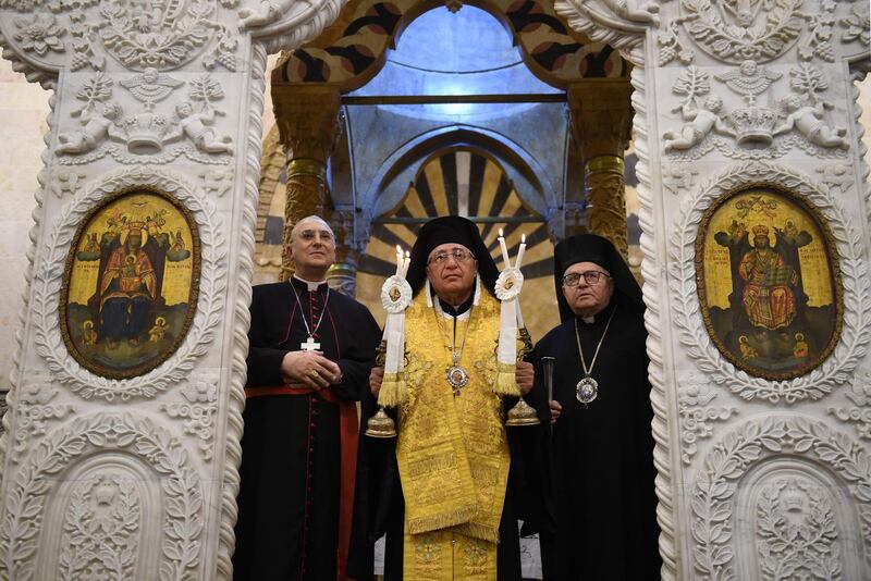 Patriarch of the Melkite Greek Catholic Church Youssef Al Absi, centre, leads prayers  during the re-opening of the Greek Catholic Church of Our Lady, in Aleppo. All photos by AFP
