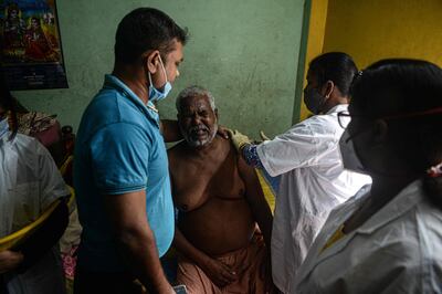 A health worker inoculates an elderly person during a door-to-door vaccination drive. AFP