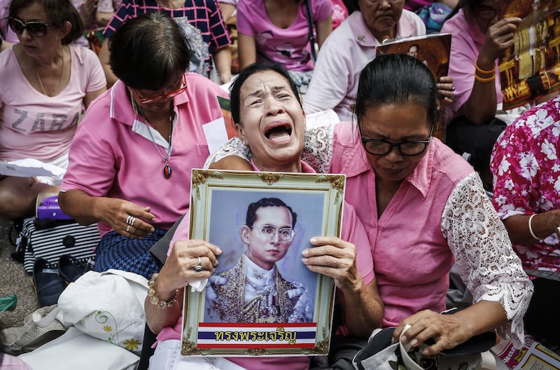 A Thai well-wisher weeps as she is comforted during a prayer for Thai King Bhumibol Adulyadej who died on October 13, 2016. Rungroj Yongrit/EPA