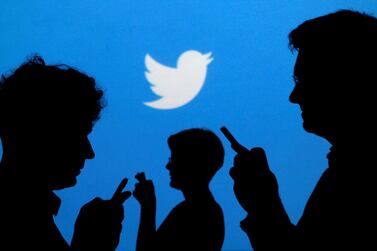FILE PHOTO: People holding mobile phones are silhouetted against a backdrop projected with the Twitter logo in this illustration picture taken in  Warsaw September 27, 2013.   REUTERS / Kacper Pempel / File Photo
