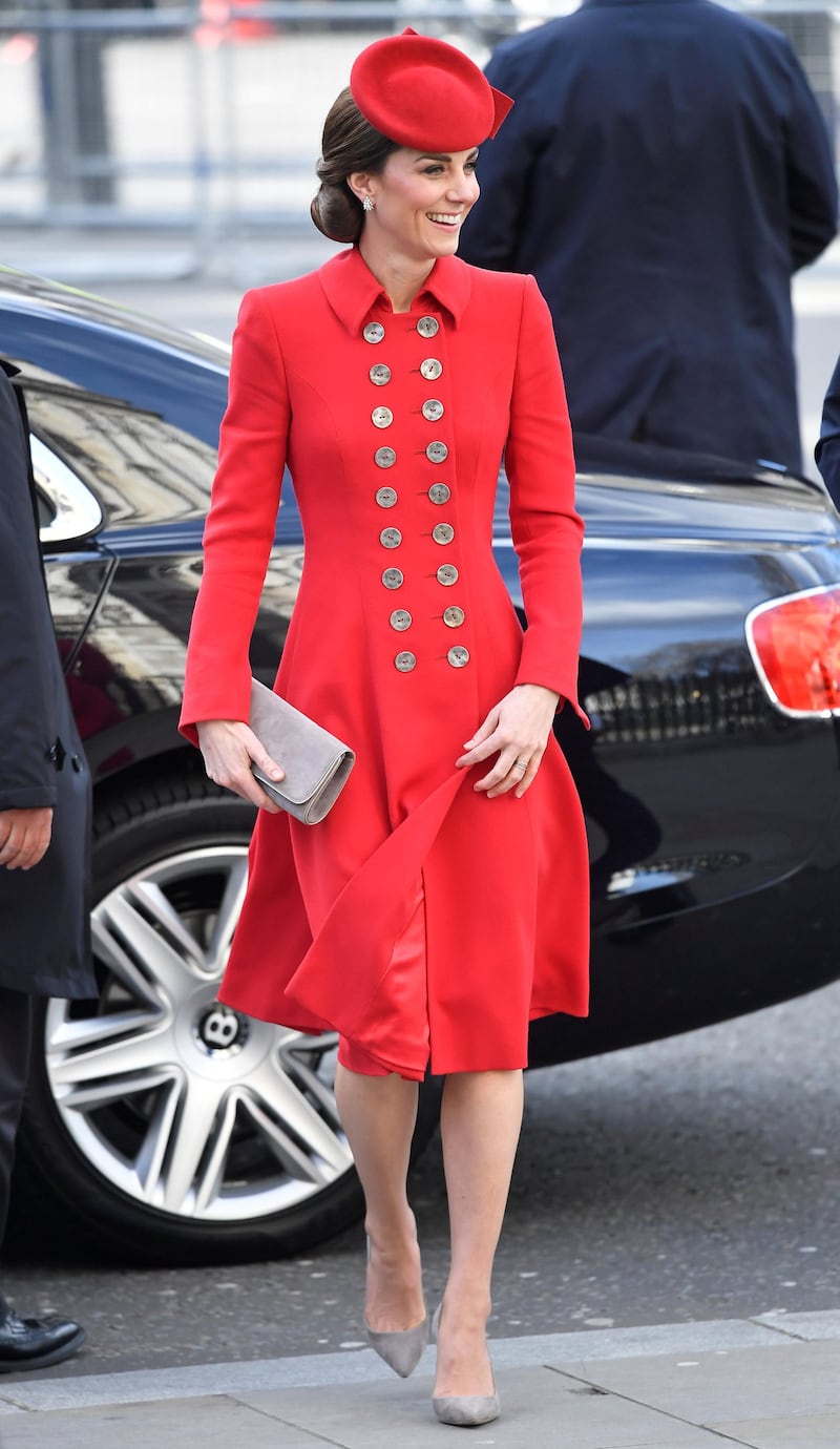 The Duchess of Cambridge wears buttoned red coat by Catherine Walker for the Commonwealth Service at Westminster Abbey on March 11, topped off with a suede clutch and pumps by Emmy London. The Duchess previously wore the look to New Zealand. Reuters