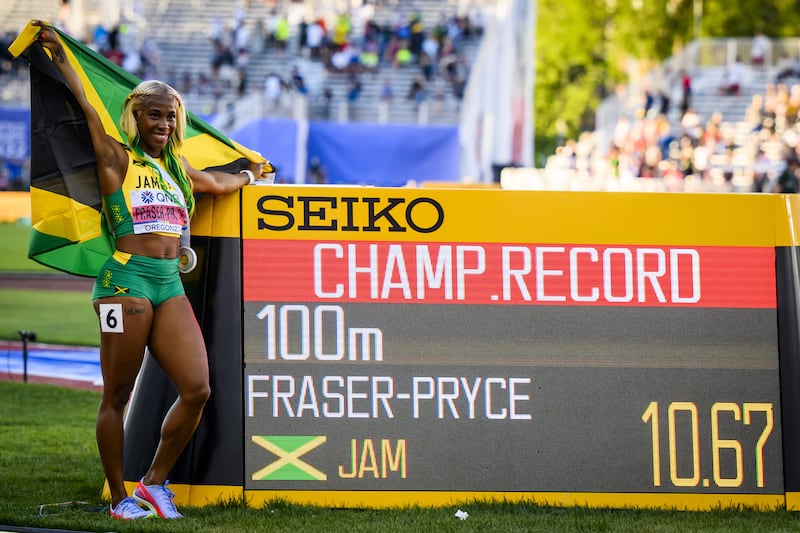 Shelly-Ann Fraser-Pryce celebrates next to the board displaying her championship record time following her victory in the 100m. EPA