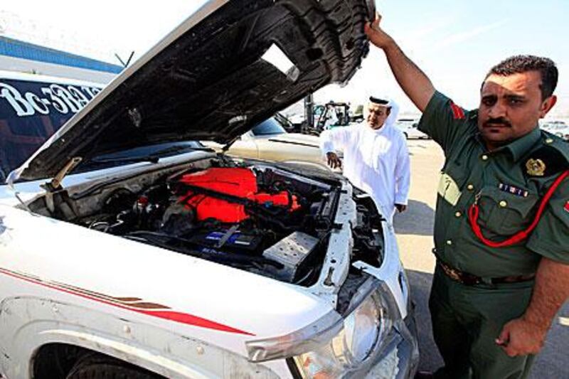 Members of the Dubai Police department with one of the cars, which was modified to use jet fuel, that they caught racing at 300kph on the Dubai bypass.