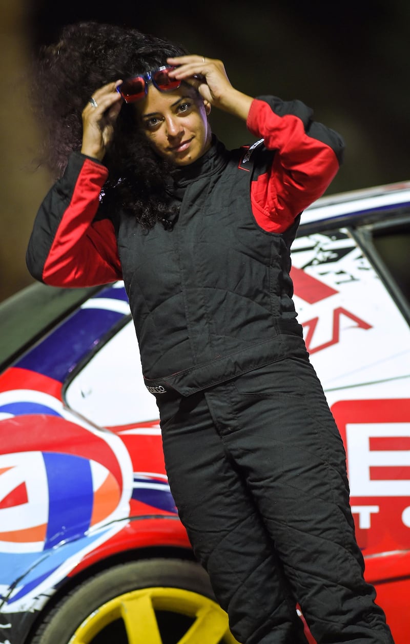 Palestinian drift-racer Noor Daoud poses by her car during a competition held at the Track Ghibli in Egypt's Red Sea resort city of Sharm El Sheikh on September 28, 2018. Noor Daoud was the only woman to take to the track in Egypt's Red Sea resort of Sharm el-Sheikh, where the Palestinian racer impressed the crowds with her "drift" driving skills. She is also the only Arab woman to have reached the international level of "drift", where drivers deliberately oversteer to make the rear wheels skid in the sport which emerged in Japan in the 1970s. / AFP / Mohamed el-Shahed
