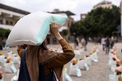 A worker carries a sack of wheat flour during the distribution of food aid in Sanaa, Yemen, last April. Reuters