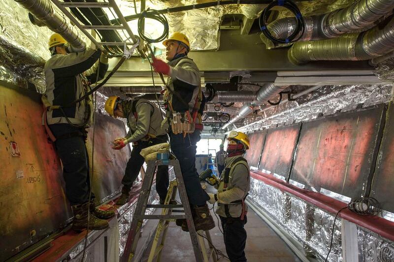 Workers add wiring to the bridge of an under-construction Maersk triple-E class container ship. Ed Jones / AFP