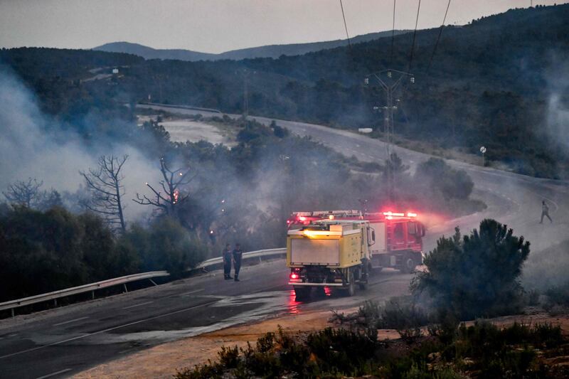 Firefighters try to extinguish a forest fire raging near the town of Melloula in northwestern Tunisia, close to the border with Algeria. AFP