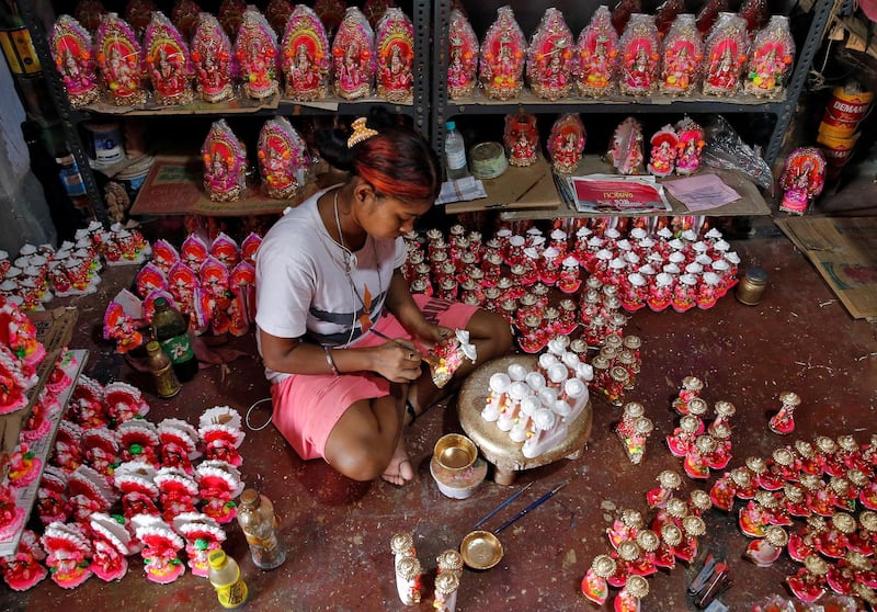 A woman paints idols of Hindu god Ganesh, the deity of prosperity, and goddess of wealth Laxmi, which will be worshipped during Diwali, the Hindu festival of lights, at a workshop in Kolkata, India October 18, 2019. Reuters