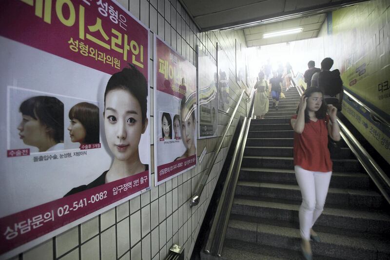 Signs of plastic surgerys are seen at the entrance of subway station in Apgujeong-dong, Seoul, South Korea, on Saturday, Aug 3, 2013.
/ Photographer; Woohae Cho for Bloomberg