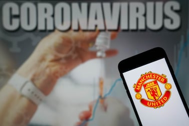 File photo dated 09-01-2021 of The Manchester United Football Club logo seen displayed on a mobile phone with a Coronavirus illustration on a monitor in the background. Manchester United are in talks with the Premier League about whether tomorrow's match at Brentford should go ahead and have closed down first-team operations at their Carrington training base for 24 hours to minimise risk of further Covid-19 infections, the club have announced. Issue date: Monday December 13, 2021.