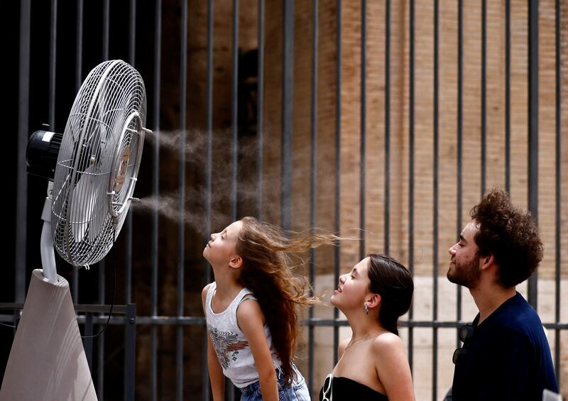 People stand in front of a cooler installed near the Colosseum amid a heatwave in Rome. Reuters