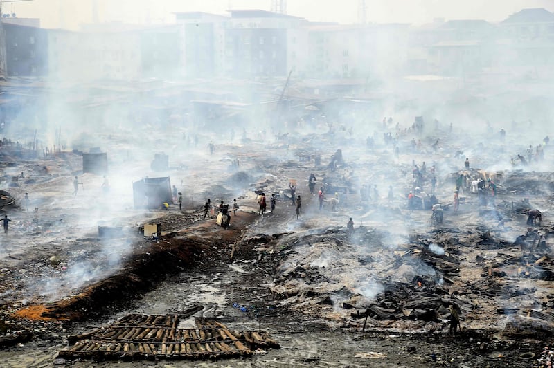 Workers and locals attempt to salvage goods after a fire at Oko-Baba Sawmill, in the Ebute-Metta district of Lagos, Nigeria. Hundreds of people were displaced by the blaze in the city's biggest timber market. AFP