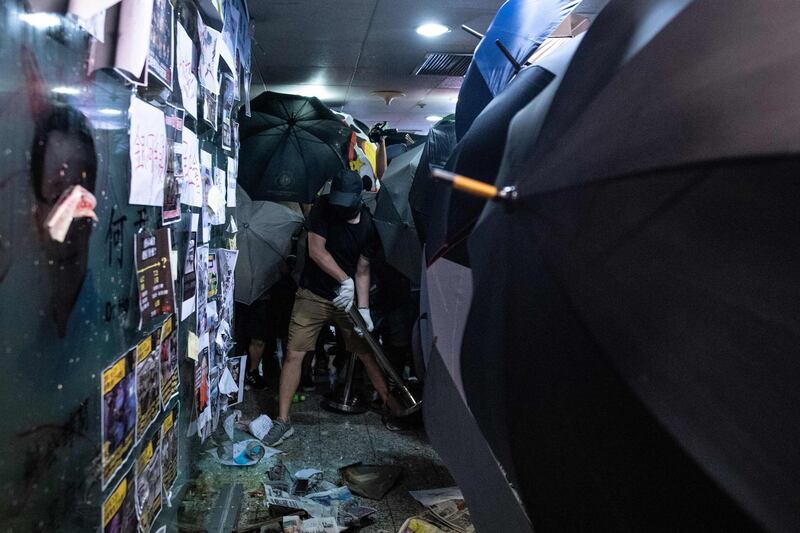 Protesters smash the glass entrance to the office of Mr. Ho in Hong Kong's Tsuen Wan district. AFP