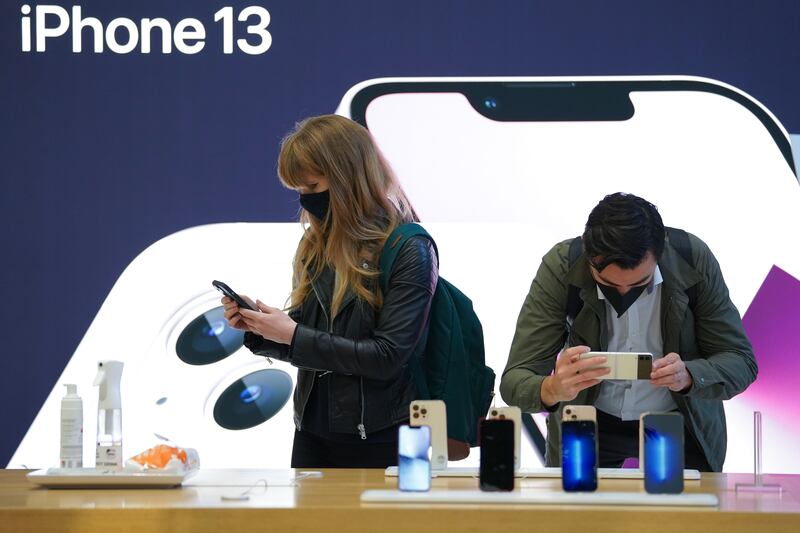 Customers look at the new Apple iPhone 13 at the tech giant's flagship store in Regent Street, London. PA