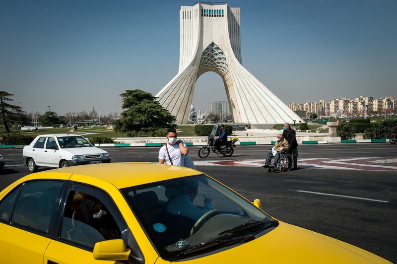 A pedestrian wears a protective face mask in Tehran, March 15. Bloomberg