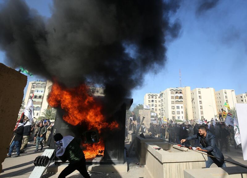 Iraqi protesters set fire to a sentry box in front of the US embassy building in Baghdad to protest against US air strikes on several bases belonging to the Kataib Hezbollah militia. AFP