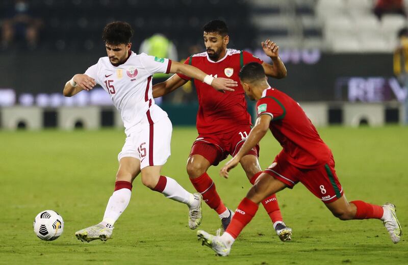 Qatar's Bassam Hisham Al Rawi tries to escape with the ball.