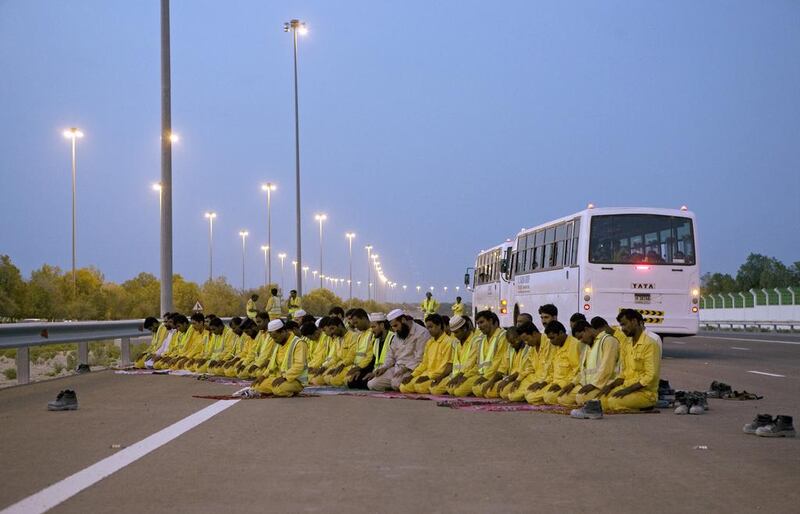 Labourers stop to pray on Sheikh Zayed Road. Irregular meals and evenings of prayers affect alertness. Jeff Topping / The National