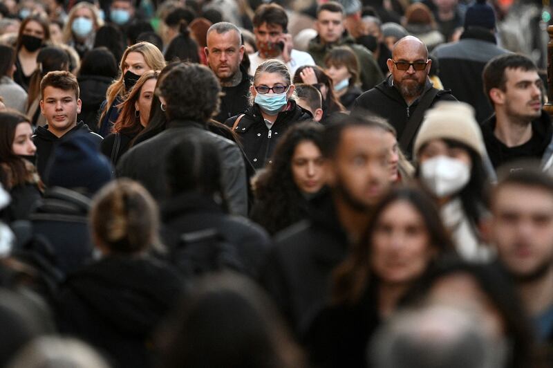 Shoppers, some wearing face-masks, walk along Oxford Street in central London, as compulsory mask wearing in shops is reintroduced in England.  AFP