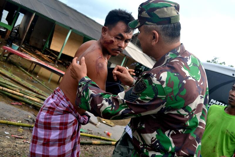A soldier takes care of a local resident in Pandeglang. Reuters