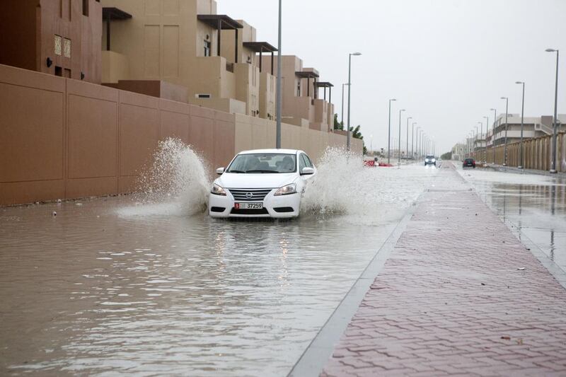 A car drives through a flooded street after the storm ay the Al Rayyana complex in the Khalifa City area of  Abu Dhabi on March 9, 2016. Christopher Pike / The National