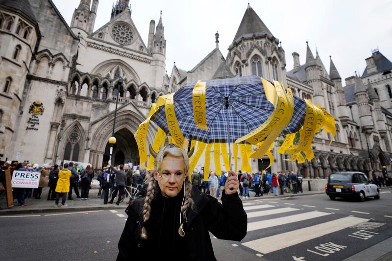 A demonstrator wears a Julian Assange mask as supporters stage a protest against his imprisonment outside the High Court in London. AP Photo