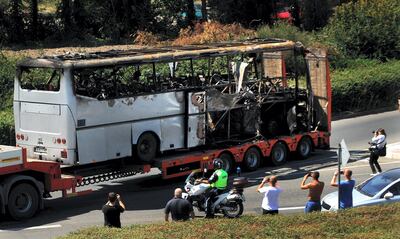 A truck carries the bus damaged by the suicide bomb blast which targeted a group of Israeli tourists at the airport in Bourgas, Bulgaria, on July 19, 2012. Bulgaria said today a suicide bomber dressed as a tourist and with fake US ID was behind an attack on Israelis on the Black Sea that killed seven people and left two in a coma. An explosion ripped through a bus carrying Israeli holiday-makers on July 18, in the Bulgarian Black sea port of Bourgas, and killed seven people in an attack the government in Israel blamed on arch foe Iran.  AFP PHOTO / NIKOLAY DOYCHINOV (Photo by NIKOLAY DOYCHINOV / AFP)