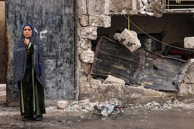 A woman stands outside a house destroyed in Israeli bombardment in Rafah, in the southern Gaza Strip, on December 20, 2023. AFP