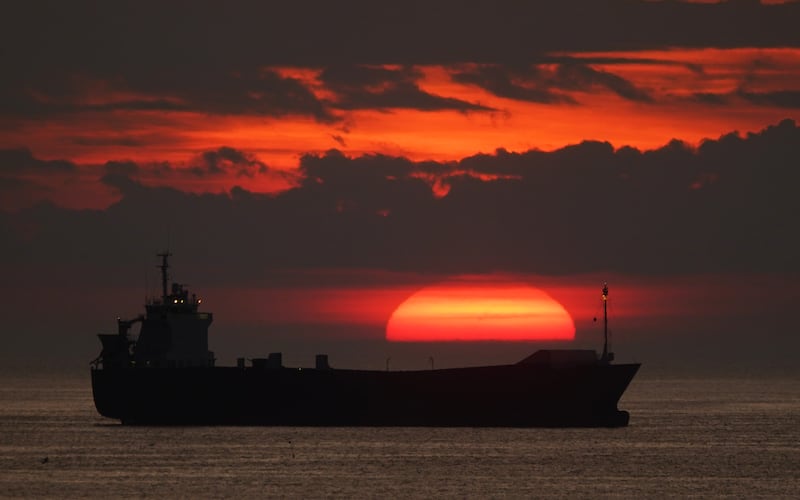 The sun rises over a cargo ship near Cullercoats Bay on North Tyneside. PA
