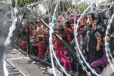 Refugees behind a fence at the Hungarian border with Serbia during the 2015 crisis. AFP 
