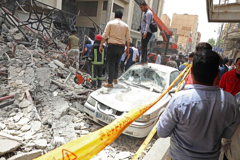 People gather at the site of the building collapse. Tasnim News / AFP